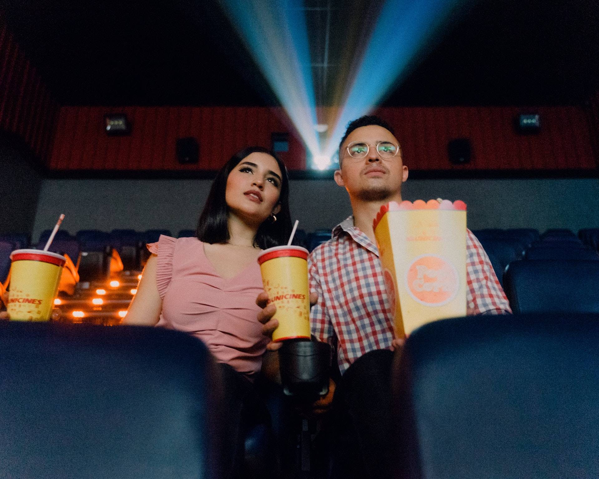 A guy and girl watching movie in the cinema while eating popcorn -  Darren Yaw Singapore